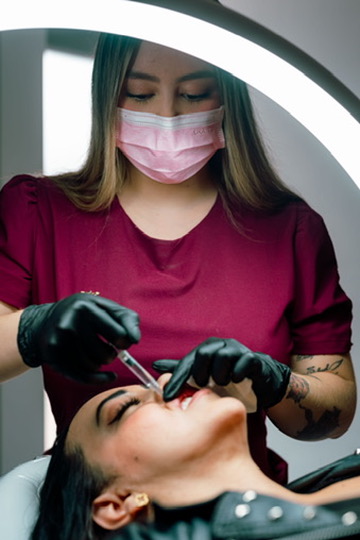 Profesional aplicando relleno de labios con ácido hialurónico